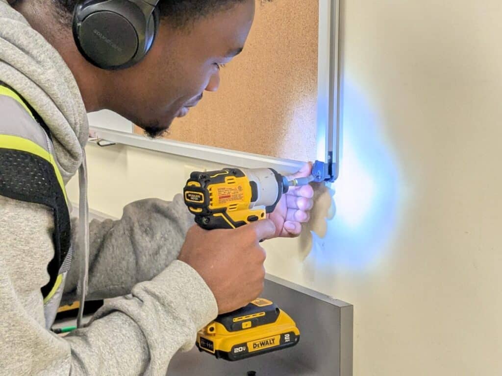 Fresh Family crew member drilling during an interior build-out