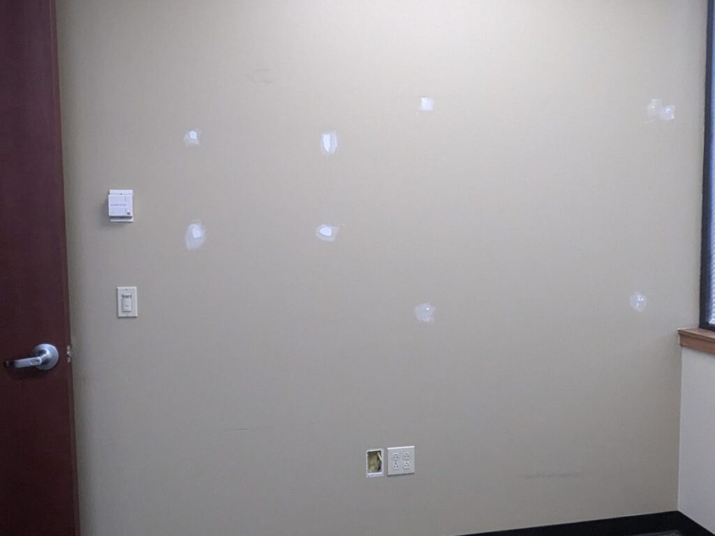 Office wall with patched holes before painting and finishing
