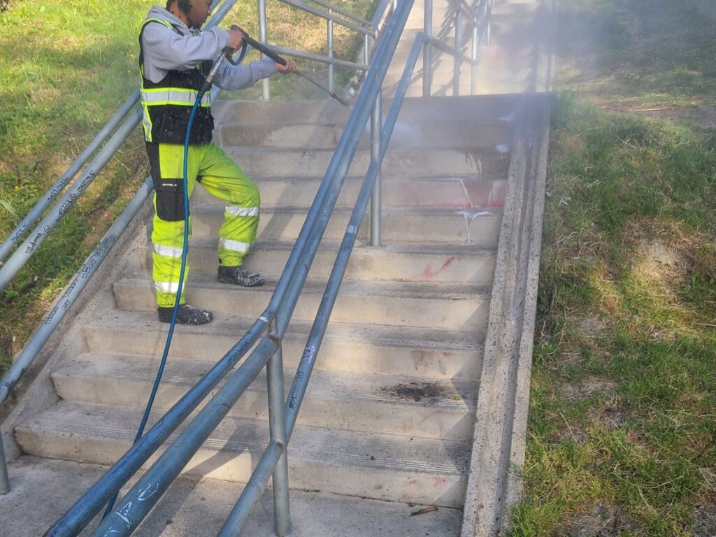 Fresh Family crew pressure washing a public stairway near 12th and Jackson