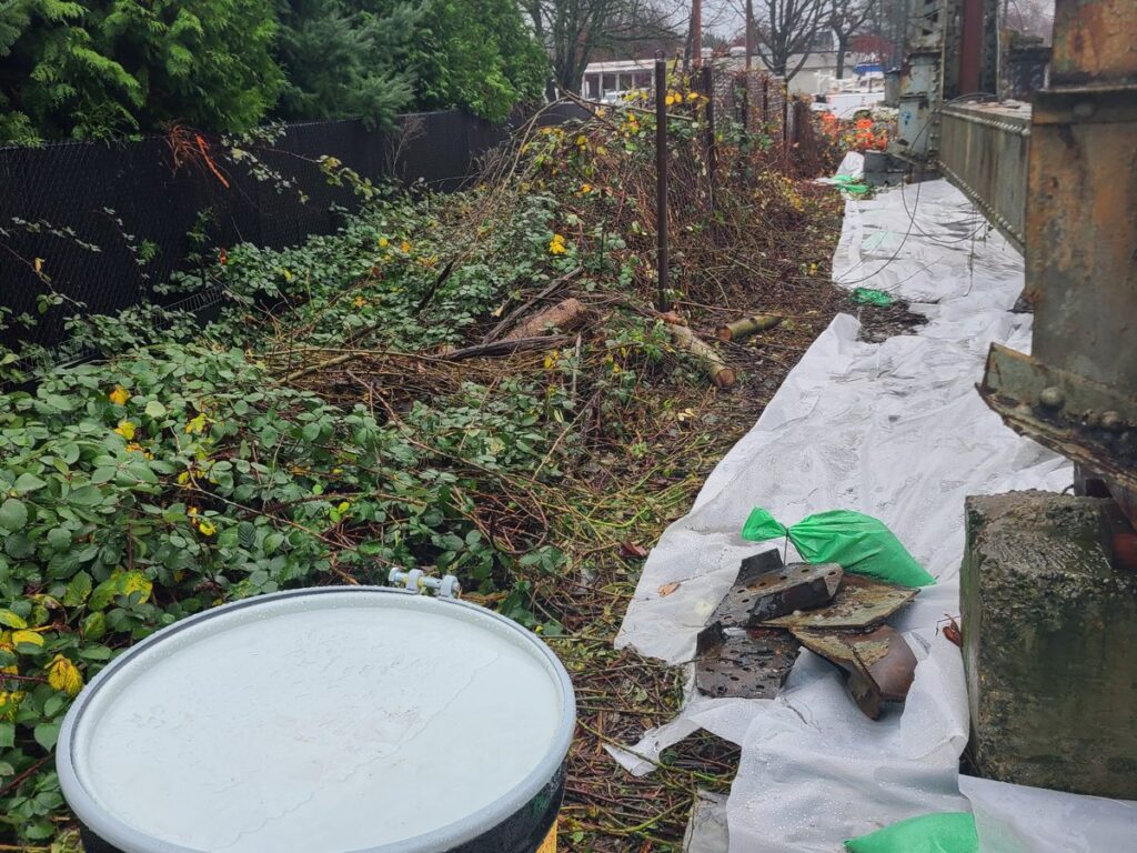 Waste drum staged on containment along the SR 167 bridge work area