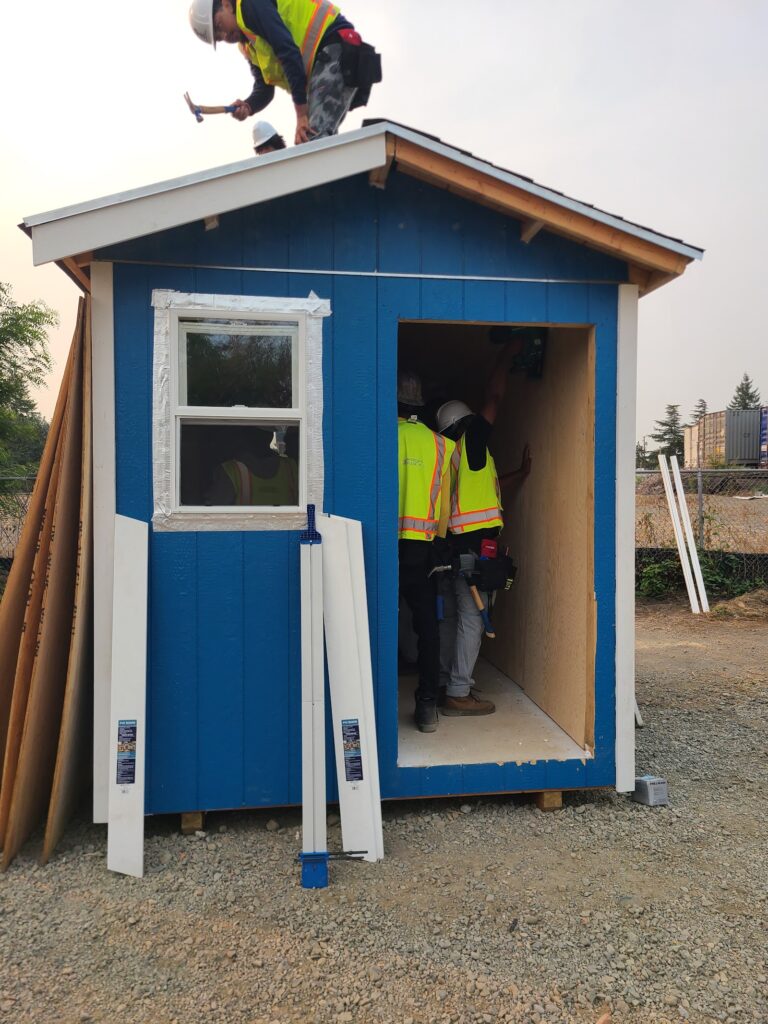 Finished Building Futures tiny home with trainee at the door